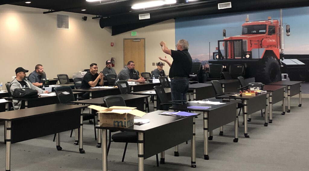 An AFVi instructor teaches vehicle technicians about CNG safety and fuel system inspections.